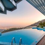 Infinity pool with breathtaking mountain and city views, perfect for a luxury tropical getaway.